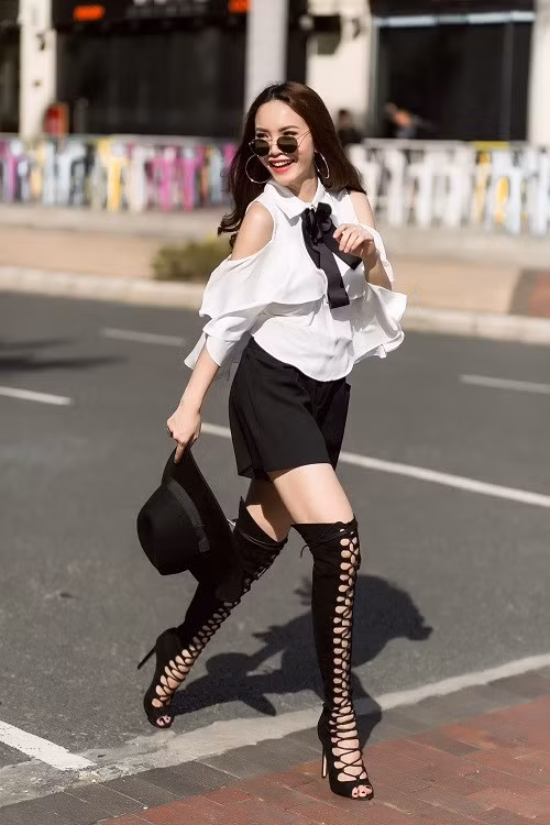 Kết hợp khá ăn ý với bộ trang phục tone đen trắng, Yến Trang nổi bật giữa đường phối với đôi boot cao buộc dây khoe đôi chân dài trắng. Ảnh: Aliza.