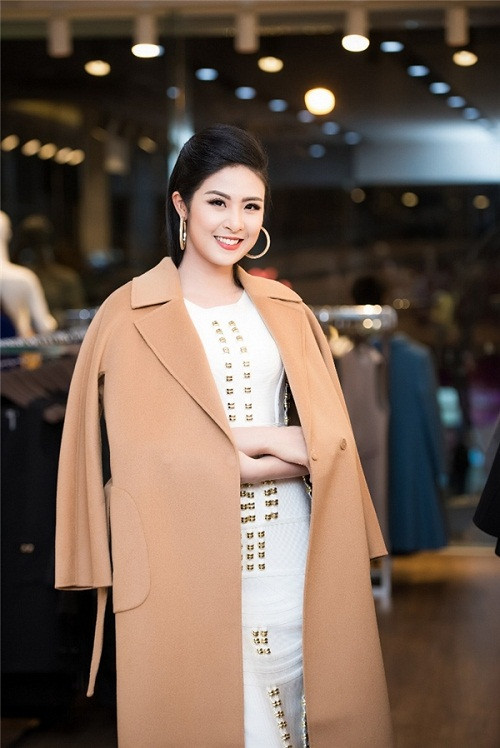 Hoa hậu Ngọc Hân đẹp kiêu sa khi diện váy trắng với điểm nhấn là những hạt kim sa đính dọc thân áo. Cô cũng chọn cho mình những thiết kế áo khoác với tông màu trầm ấm, rất phù hợp với mùa đông. Ảnh: Dân Việt.