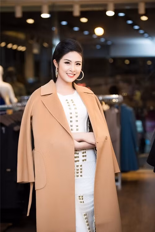 Hoa hậu Ngọc Hân đẹp kiêu sa khi diện váy trắng với điểm nhấn là những hạt kim sa đính dọc thân áo. Cô cũng chọn cho mình những thiết kế áo khoác với tông màu trầm ấm, rất phù hợp với mùa đông. Ảnh: Dân Việt.