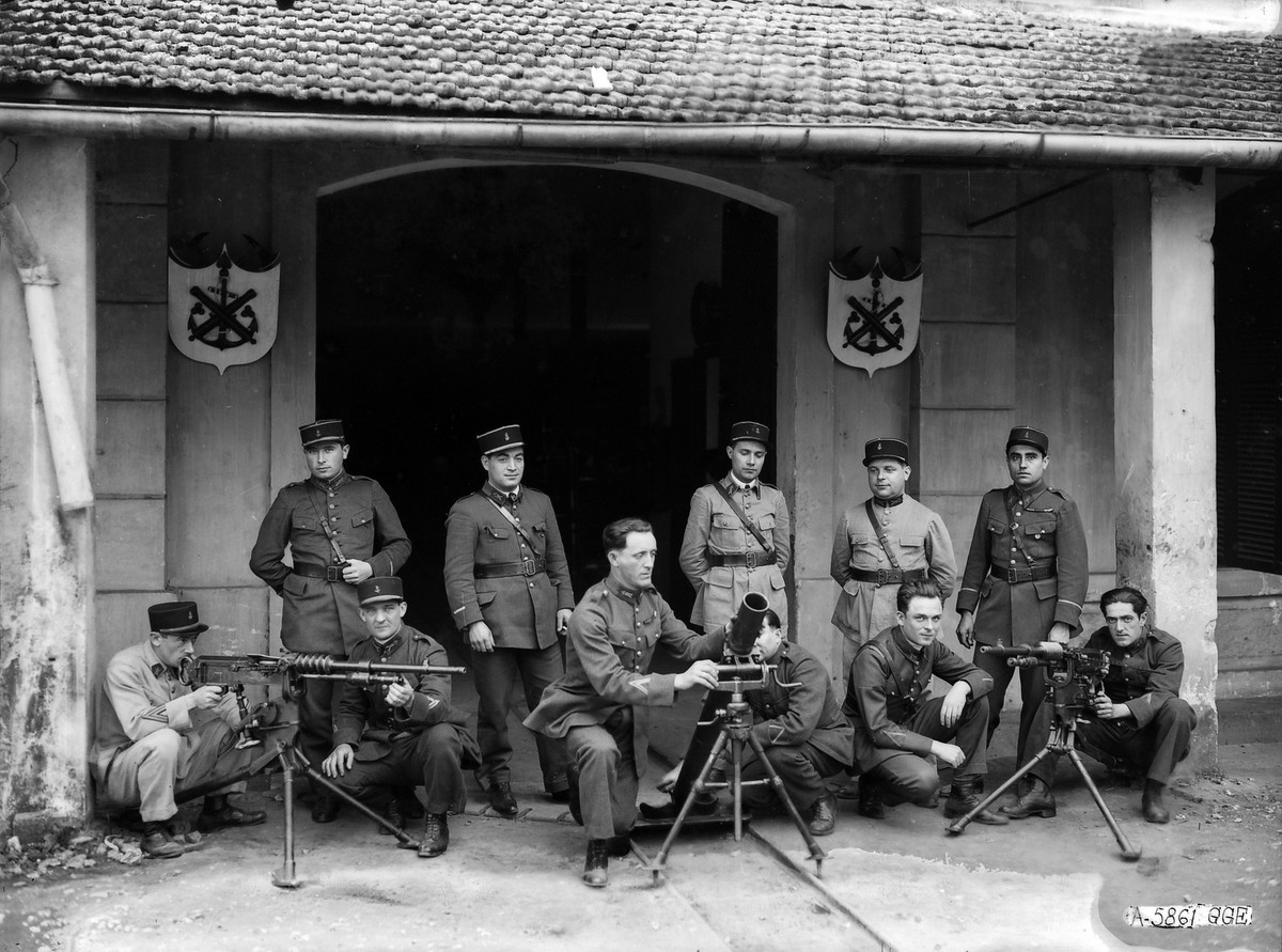 Sĩ quan Pháp kiểm tra súng máy, pháo cối bên ngoài kho vũ khí.