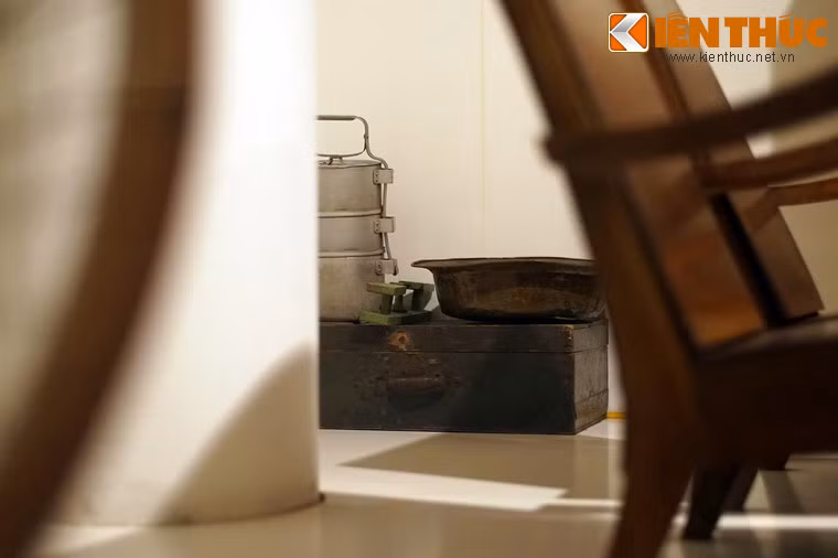 Hòm gỗ quân đội được tận dụng để đựng đồ, cùng chậu và xoong nồi được bày ở góc phòng.