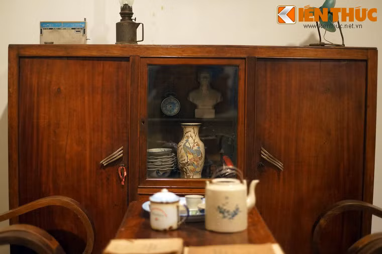 Chiếc tủ gỗ đơn sơ, ở giữa có cánh cửa kính, là nơi trưng bày những món đồ quý giá như đồng hồ, đồ gốm...