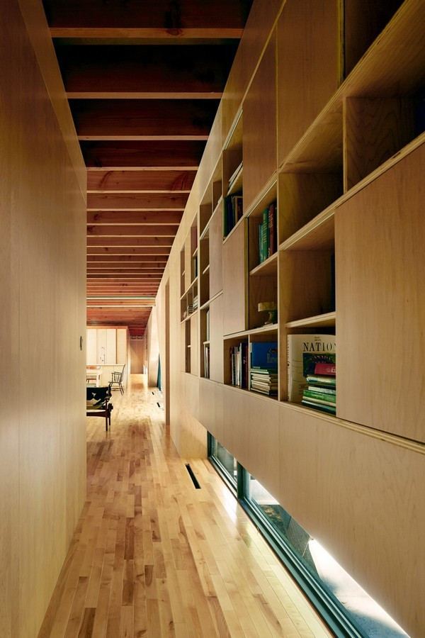 Ở hai mặt ngôi nhà, một bên gồm các tấm cửa kính trượt lớn tạo không gian mở liên kết ngôi nhà với môi trường bên ngoài. Ở mặt còn lại, các bức tường hoàn toàn làm bằng kính, cung cấp tầm nhìn ra khu rừng phía xa.