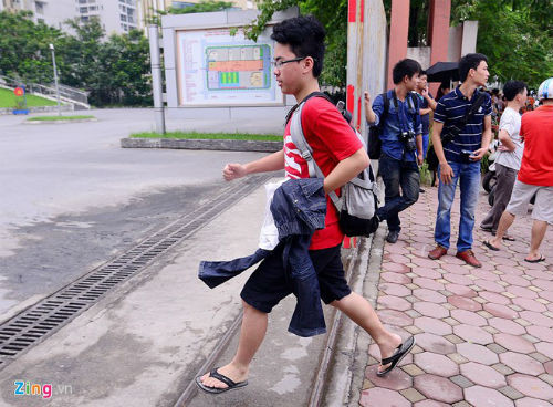 Một thí sinh nam sau khi được bố mẹ mang quần dài đến, vội vã chạy vào trường để thay trang phục.