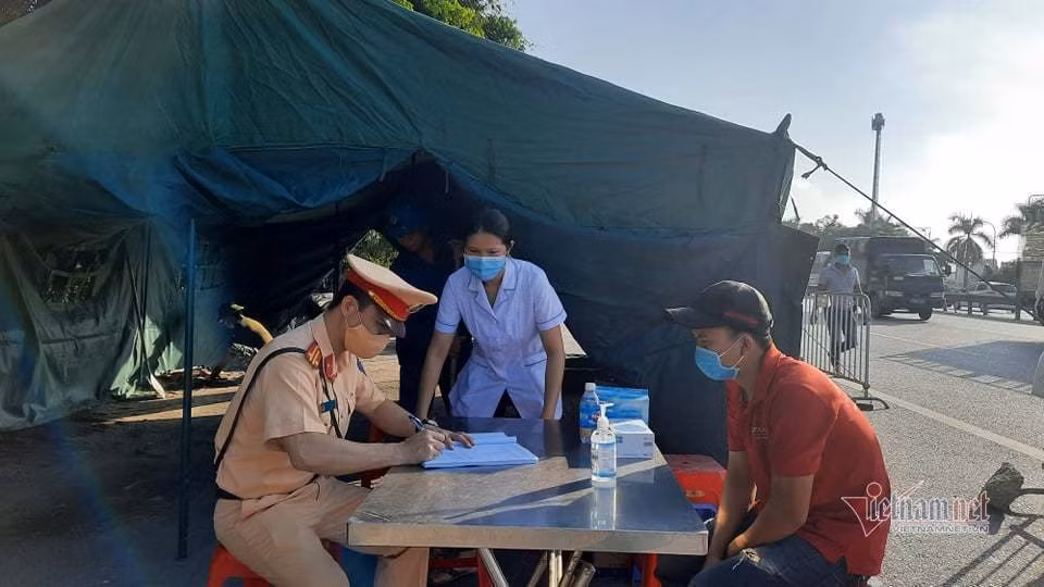 Khi lái xe đến khai báo, nhân viên y tế sẽ đo thân nhiệt, yêu cầu ghi rõ nơi đi về và giấy tờ lưu hành, gồm giấy xác nhận của địa phương không phải vùng dịch, giấy xét nghiệm âm tính với Covid-19. (Ảnh: Nhị Tiến