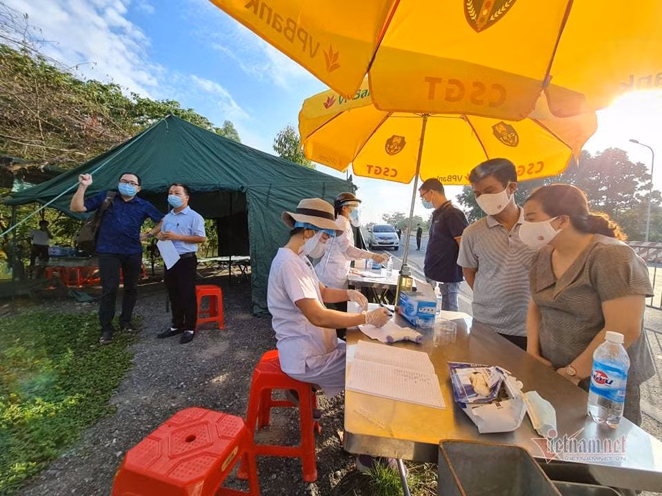 Đoạn đường dẫn vào chốt kiểm soát được lực lượng chức năng đặt lớp barie để phân luồng các dòng xe. Một cán bộ CSGT cho VietNamNet biết, hoạt động của chốt mang tính chất phòng ngừa dịch bệnh xâm nhập vào thành phố. Người dân khai báo y tế, đo thân nhiệt trước khi vào TP Hà Nội tại chốt cầu Vĩnh Thịnh. Ảnh: Đoàn Bổng.