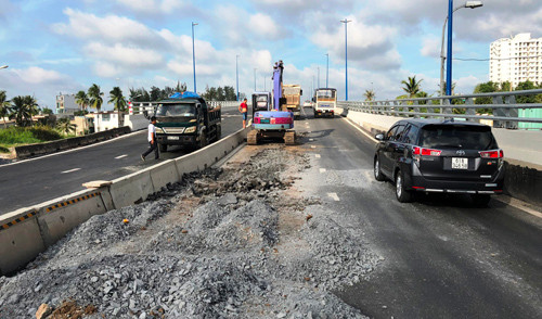 Rất đông công nhân, phương tiện được tập kết để sửa chữa sụt lún đường dẫn của cây cầu mới vừa thông xe.