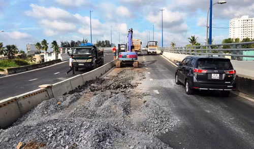 Rất đông công nhân, phương tiện được tập kết để sửa chữa sụt lún đường dẫn của cây cầu mới vừa thông xe.