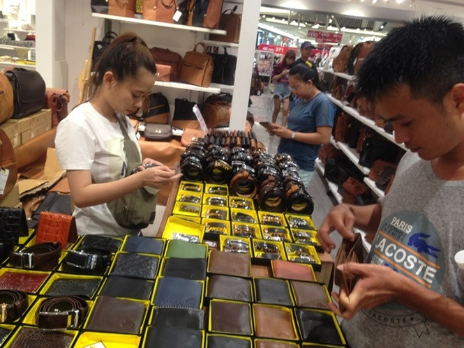 Ở các quầy hàng giảm giá, khách tập trung rất đông để săn hàng hiệu .