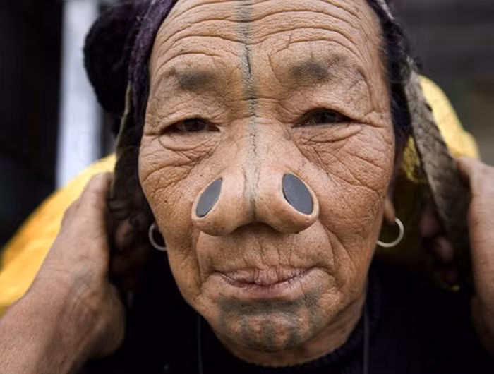 Những người Apatani cho rằng, việc nhét đồng xu vào mũi như thế sẽ tránh được việc bị đàn ông các bộ tộc khác bắt cóc về làm vợ nhờ vẻ ngoài xấu xí .