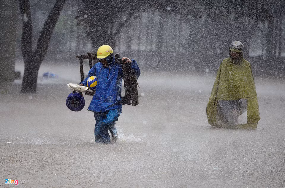 Mưa lớn, nhiều người vẫn phải ra đường vì nhiều việc khác nhau. Ảnh: Lê Hiếu.