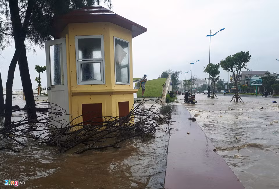 Mặc dù lúc này mưa không lớn nhưng nước từ biển tràn qua khiến một số tuyến đường bị ngập. Trước diễn biến phức tạp, đơn vị chức năng đã huy động xe tải chở từng khối đá tảng lớn và xe cẩu đến bảo vệ bờ kè và tuyến đường này. Ảnh: Nguyễn Dương.