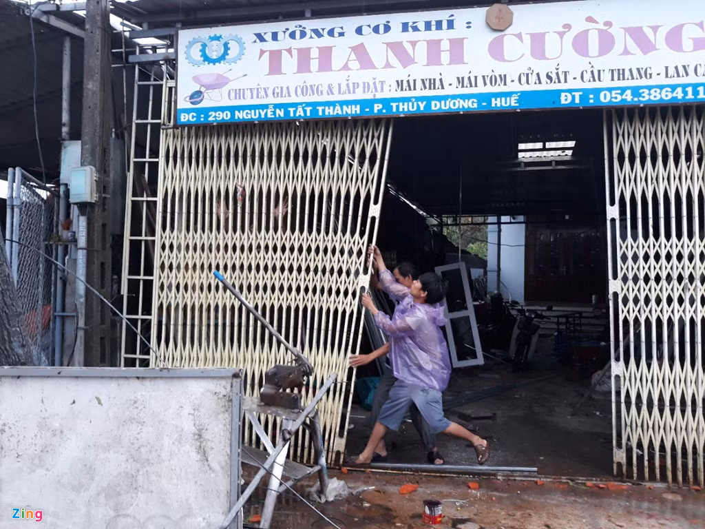 Cửa sắt của một xưởng cơ khí bị hư hỏng sau cơn lốc. Ảnh: Điền Bá Quang