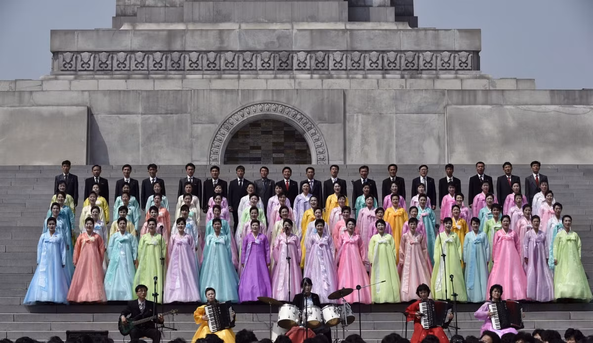 Phụ nữ mặc trang phục truyền thống hát dưới chân tháp Juche nhân kỷ niệm ngày sinh nhật của nhà lãnh đạo Kim Il-sung. Ảnh do nhiếp ảnh gia Robichon của Hãng thông tấn châu Âu (EPA) thực hiện.