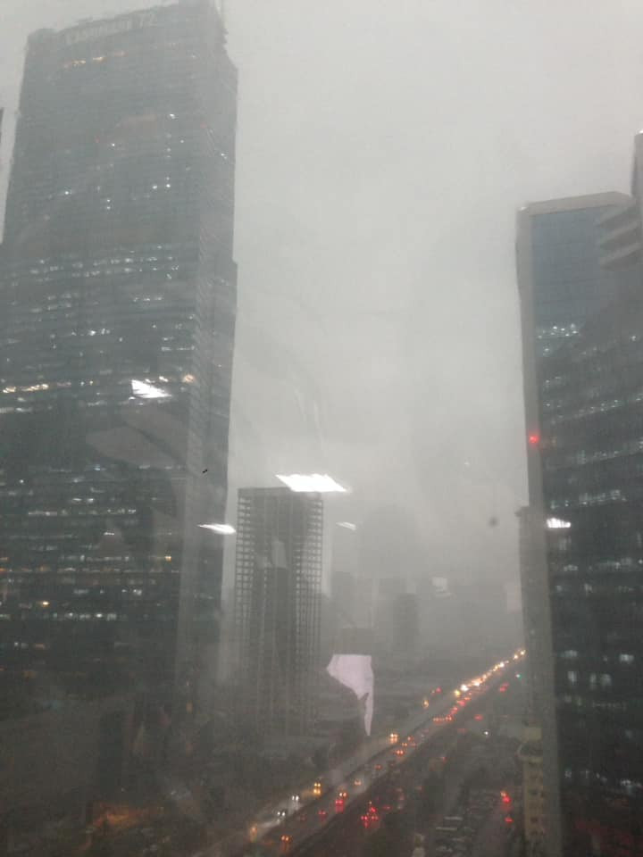 Dù mới 14h chiều (20/8), trời đang quang - sáng bỗng dưng tối sầm. Đến 14h30, mưa lớn bắt đầu trút xuống. Người lưu thông trên đường đều phải bật đèn pha, các cửa hàng, văn phòng cũng đua nhau sáng điện. (Ảnh PLO) 