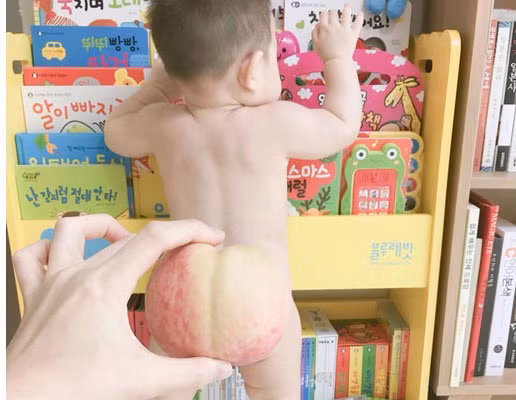 Chắc hẳn cậu bé này không biết mẹ lén chụp mình khi đang lục sách.