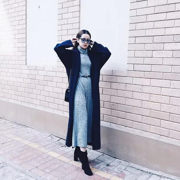 Chi Pu “thả dáng” trên phố trong mẫu đầm len cổ lọ được phối cùng áo cardigan dáng dài và boot màu đen. Cách chọn lựa màu sắc đối lập tạo sự cân bằng cho tổng thể trang phục giúp diện mạo của nữ diễn viên đa tài thêm hút hồn. Ảnh: himher.vn.