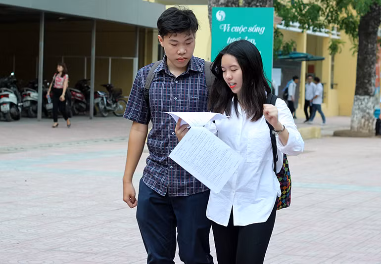 Thí sinh vừa bước ra khỏi phòng thi vừa xem lại các câu hỏi trong đề.