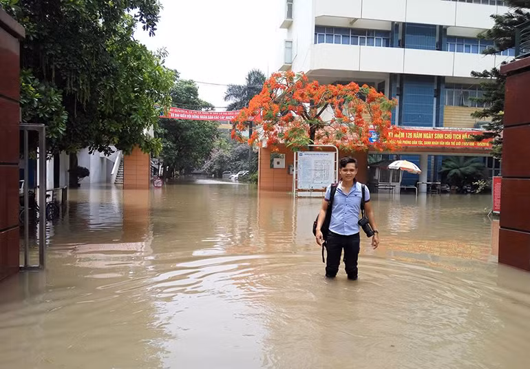 Hình ảnh phóng viên Hoàng Hải (SN 1990) báo điện tử Trí Thức Trẻ đang tác nghiệp tại một khu nước ngập sâu ở Hà Nội, trong khi xung quanh mọi người đã sơ tán hết.
