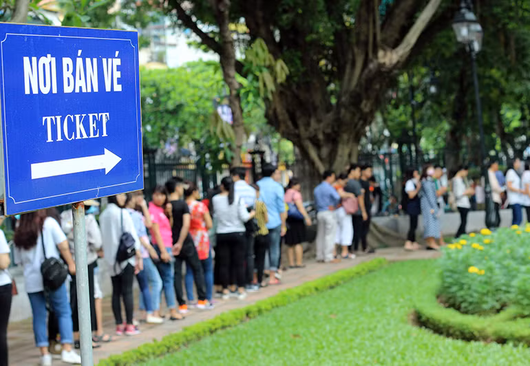 Tại khu vực phòng bán vé vào Văn Miếu - Quốc Tử Giám, các thí sinh cùng người nhà phải xếp hàng dài chờ đợi đến lượt vì còn có nhiều du khách trong và ngoài nước đến đây tham quan.