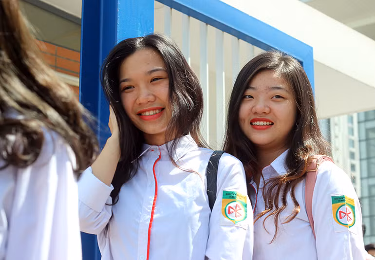 Thí sinh Lê Nguyễn An (trái) và Nguyễn Phương Trinh (phải, đều học trường THPT Nguyễn Bỉnh Khiêm, Hà Nội) cười tươi, chia sẻ: "Chúng em thấy đề Ngữ văn được đưa ra khá gần gũi, đều nằm trong chương trình học và ôn tập nên cả hai chúng em hoàn thành bài khá ổn. Chúng em tự tin bài làm có thể đạt điểm khá".