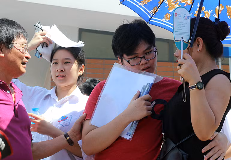 Một nam sinh vui mừng ôm lưng mẹ sau khi hoàn thành tốt bài thi.