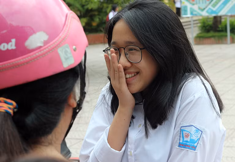 Nữ sinh không giấu nổi cảm xúc vui mừng sau khi hoàn thành tốt bài làm khi chia sẻ với phụ huynh ngay trước cổng trường thi.