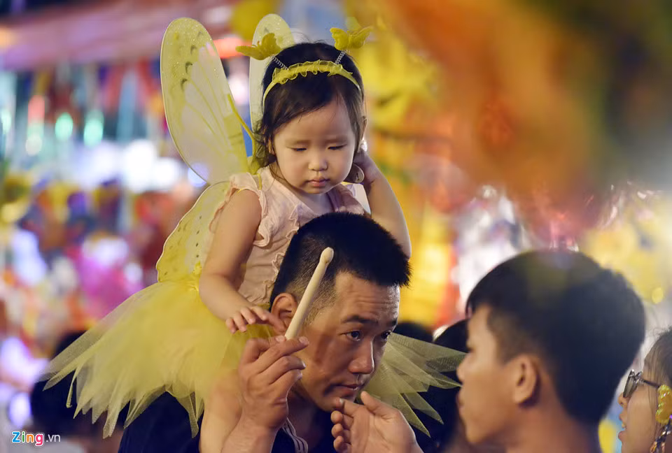 Nhiều trẻ nhỏ tỏ ra mệt mỏi khi phải chen chúc trong bối cảnh người đông nghẹt, không khí oi nóng.