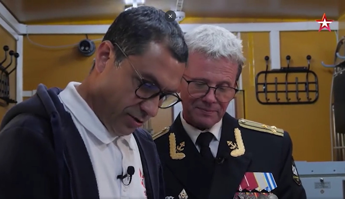 Theo như video mà kênh truyền hình Zvezda đã công bố, cho thấy một cảnh quay từ vị trí rất gần khoảnh khắc quả ngư lôi hạt nhân này phát nổ. Cựu chiến binh Alexander Zhuravlev (người mặc quân phục), phi hành đoàn máy bay trên đã rất mạo hiểm khi thực hiện việc ghi hình, khi họ rời khỏi địa điểm đó, sóng xung kích đã đẩy họ như có người xô phía sau. Ảnh: Zvezda