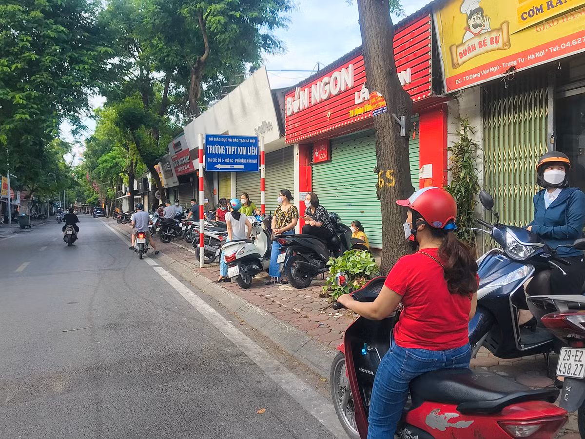 Phụ huynh chờ con em trong giờ thi tại điểm thi THPT Kim Liên (Hà Nội).