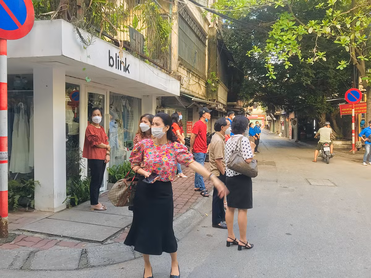 Một phụ huynh tranh thủ trong lúc đợi con hỗ trợ thí sinh đến dự thi muộn.