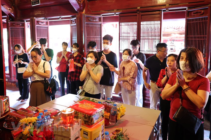 Từng nhóm phụ huynh và học sinh thành kính dâng hương và lễ vật, cầu mong cho thí sinh vượt vũ môn thành công.