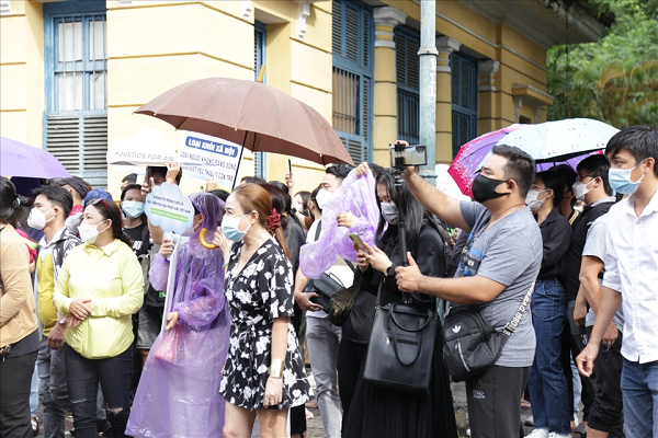 Mặc dù bên ngoài trời đang mưa nhưng nhiều người dân vẫn đứng đợi cho đến khi phiên tòa kết thúc. (Ảnh: Lao động)