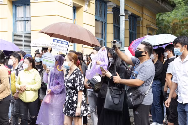 Mặc dù bên ngoài trời đang mưa nhưng nhiều người dân vẫn đứng đợi cho đến khi phiên tòa kết thúc. (Ảnh: Lao động)