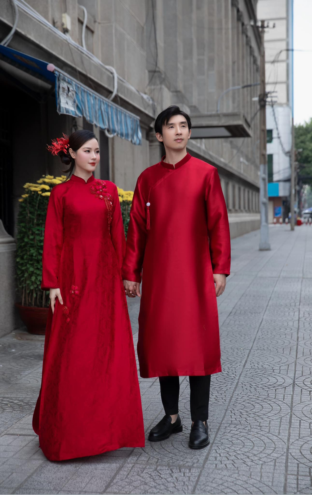 Màu đỏ rực tượng trưng cho sự may mắn và thịnh vượng, đồng thời rất phù hợp với không khí Tết, khiến hình ảnh của Midu và chồng càng trở nên nổi bật hơn giữa đám đông.