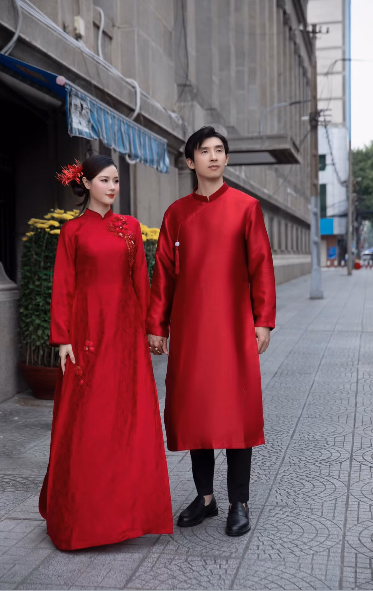 Màu đỏ rực tượng trưng cho sự may mắn và thịnh vượng, đồng thời rất phù hợp với không khí Tết, khiến hình ảnh của Midu và chồng càng trở nên nổi bật hơn giữa đám đông.