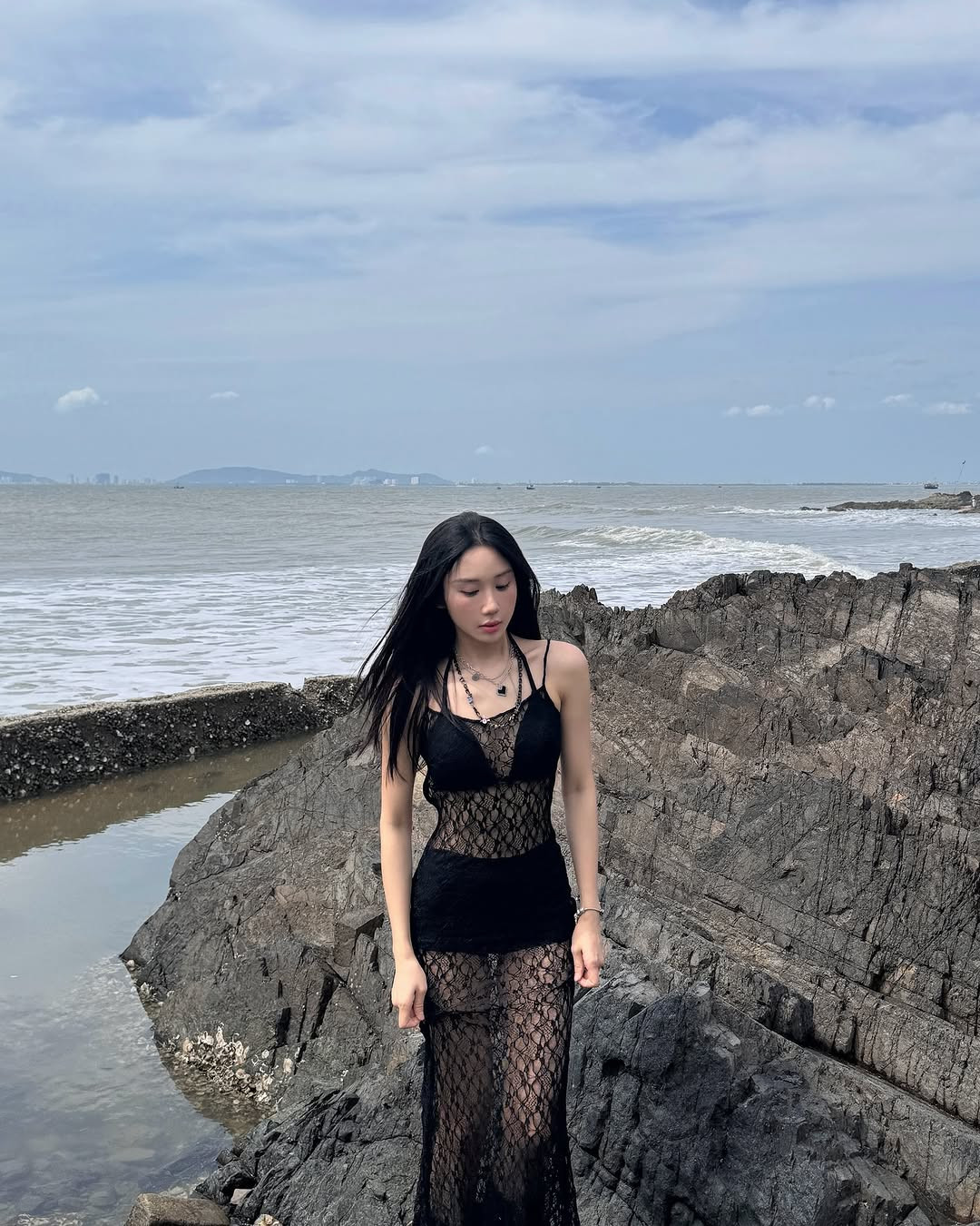 Trong loạt ảnh check-in ở biển, Mina Young lựa chọn thiết kế áo tắm màu đen, bên ngoài là váy lưới màu đen.