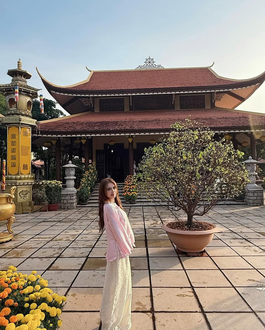 Cô nàng buông xõa mái tóc, trên tay đeo tràng hạt bình an.