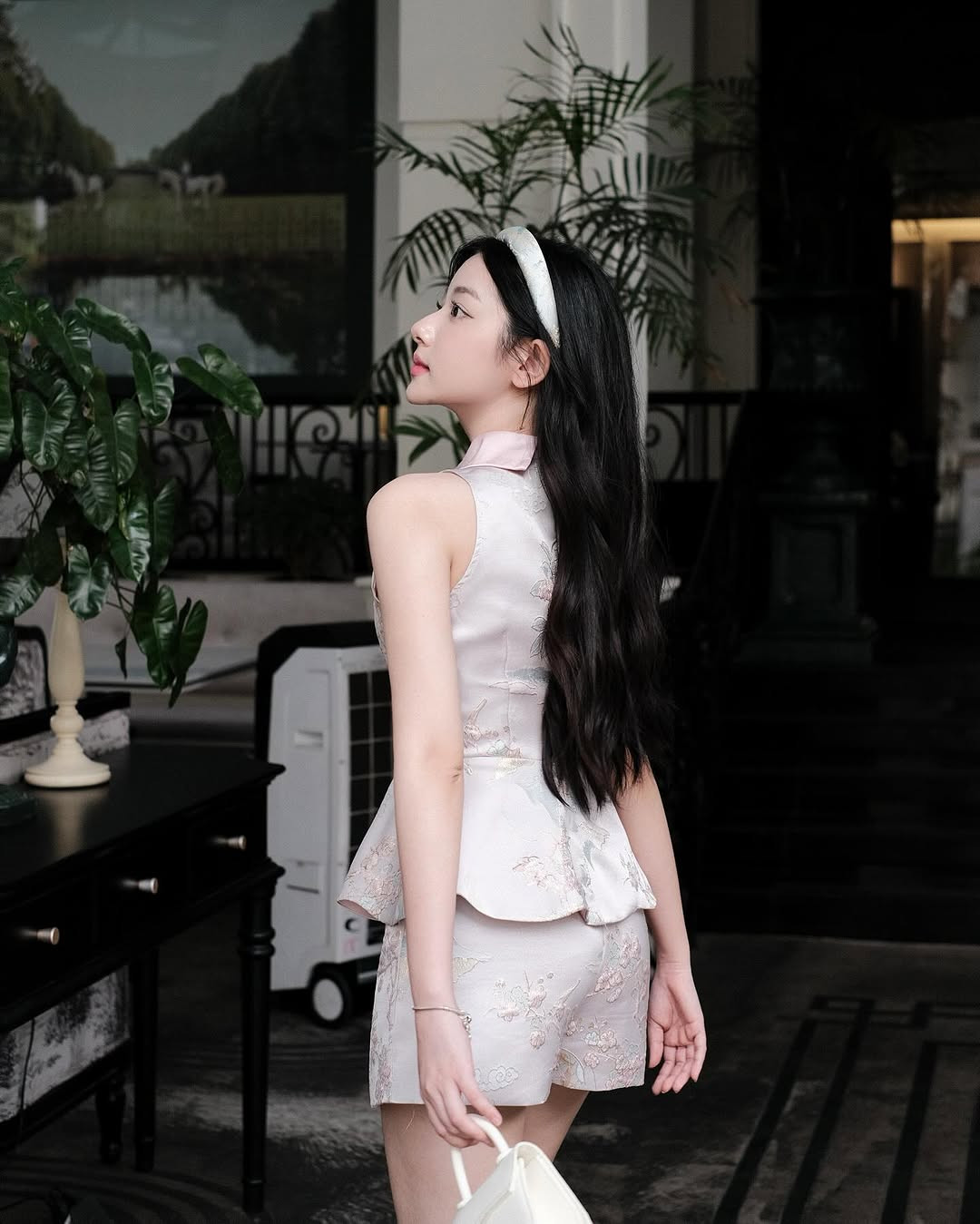 Cô nàng diện set đồ với tone trắng hồng tiểu thư nhẹ nhàng, kết hợp với kiểu tóc thả tự nhiên.