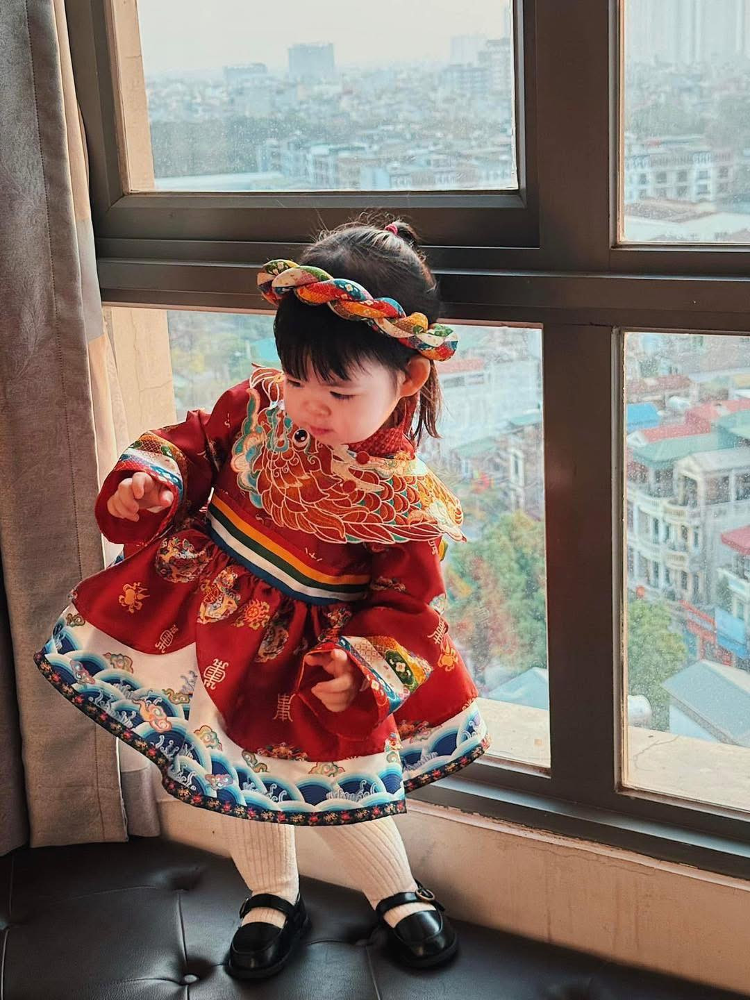 Bộ váy được thiết kế theo phong cách truyền thống nhưng vẫn mang nét hiện đại, giúp tôn lên sự đáng yêu và sang trọng của bé.