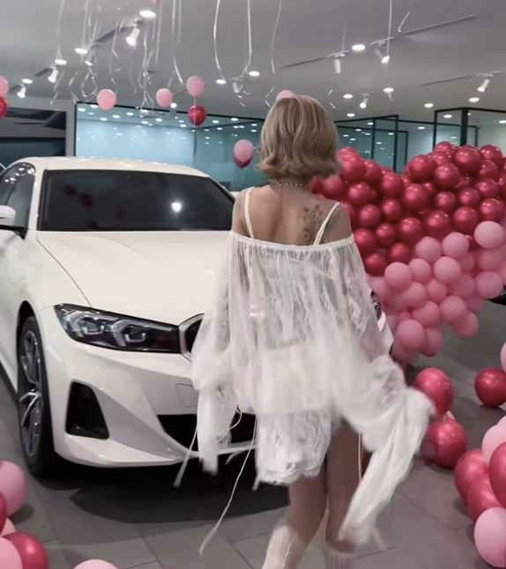 Xuất hiện trong clip, cô đứng cạnh mẫu BMW 320i Sport Line phiên bản mới, với biển số mang tên CiiN.