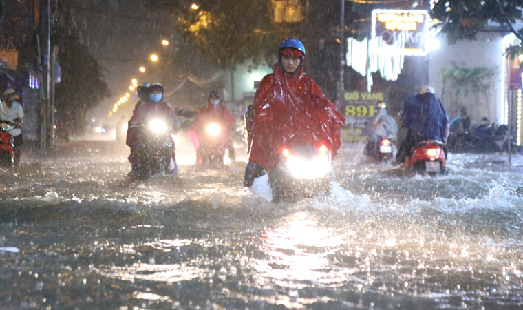 Nước ngập lút cả bánh xe khiến người dân "lóp ngóp" lội nước về nhà.