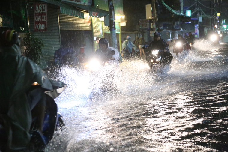 Nhiều người khác liều mình dầm mưa, lội nước vì mưa càng lớn giữa đêm khuya.