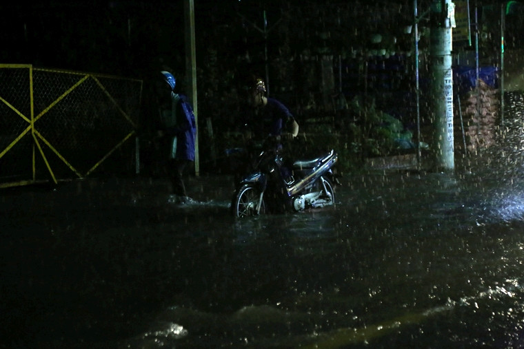 Lầm lũi dưới mưa giữa đêm khuya.