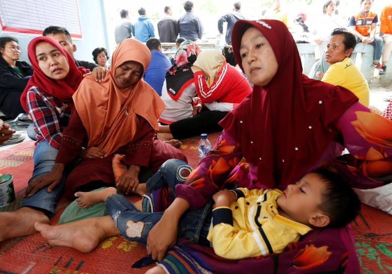 Thân thân của các hành khách mất tích ngóng chờ tin tại cảng Tigaras ở Simalungun. Ảnh: Reuters.