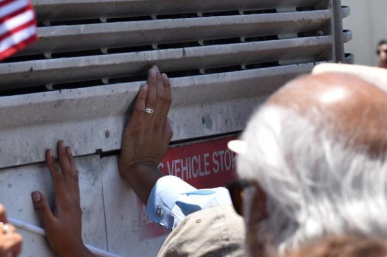 Những người biểu tình tập trung gần một chiếc xe buýt chở những người dân nhập cư gần cơ sở tạm giữ McAllen ở bang Texas ngày 23/6.