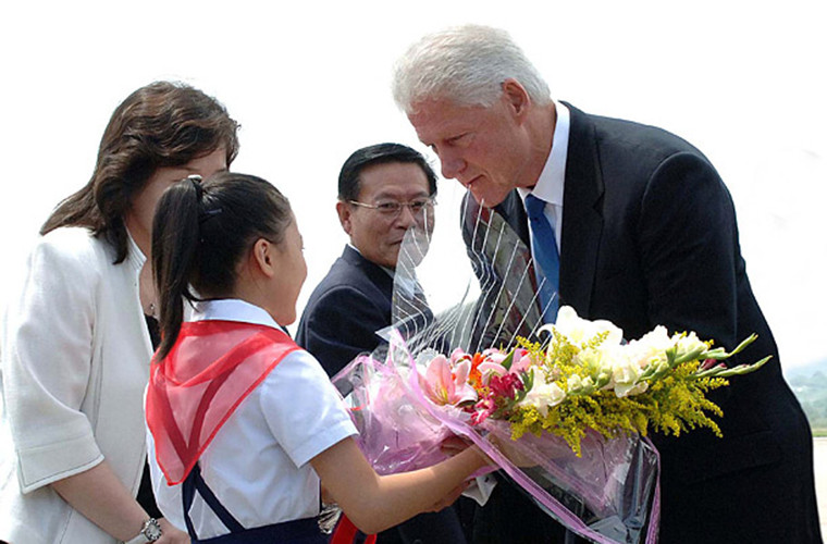 Ngày 4/8/2009, Triều Tiên đón cựu Tổng thống Mỹ Bill Clinton bằng hoa và những cái bắt tay thân mật tại thủ đô Bình Nhưỡng. Ảnh: Cựu Tổng thống Bill Clinton nhận hoa từ một em nhỏ Triều Tiên tại sân bay Bình Nhưỡng. Getty.
