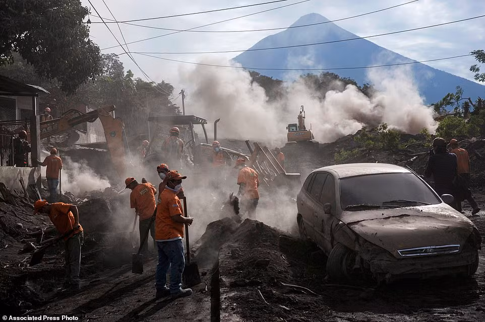 Công nhân dọn dẹp đống tro bụi ở El Rodeo sau vụ núi lửa Fuego phun trào.