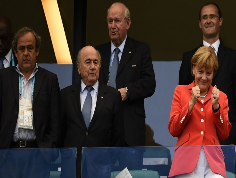 Từ trái sang hàng trên: Chủ tịch Liên đoàn bóng đá Châu Âu khi đó Michel Platini, Chủ tịch FIFA Sepp Blatter và Thủ tướng Đức Angela Merkel theo dõi một trận đấu trong bảng G giữa Đức và Bồ Đào Nha tại sân vận động Fonte Nova ở Salvador, Brazil, ngày 16/6/2014. Kết quả, Đức thắng đậm Bồ Đào Nhà với tỷ số 4-0. Ảnh: Reuters.