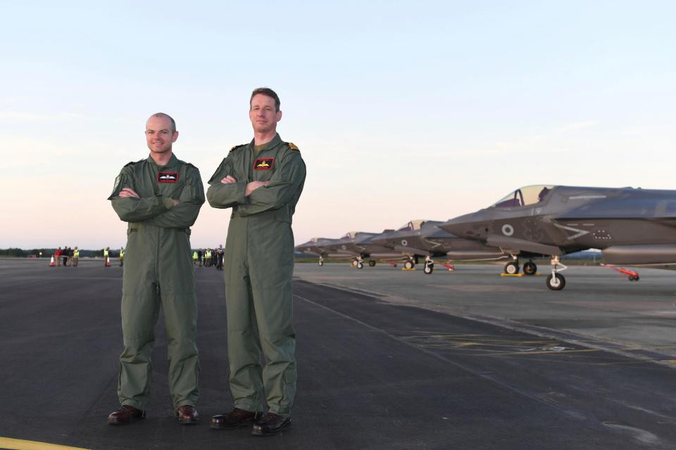 Trung úy không quân John Butcher (trái) và đồng nghiệp tại đứng trên đường băng của căn cứ RAF Marham.